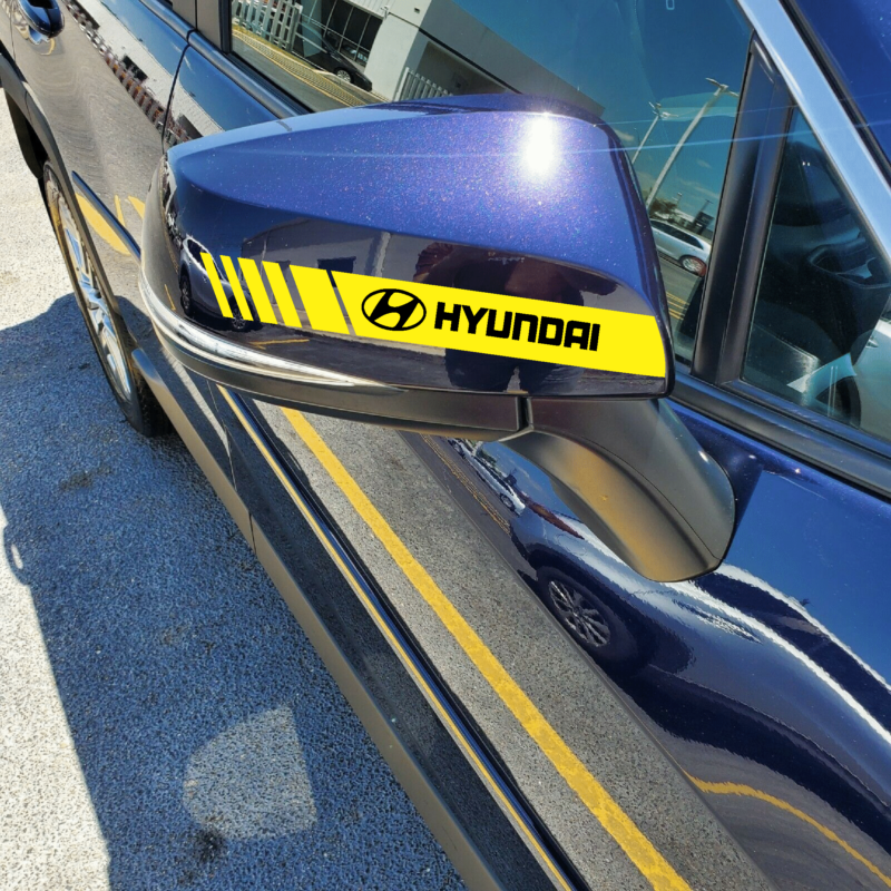 Gray Hyundai i20 with Hard Goat side mirror sticker, yellow stripes black logo visible.